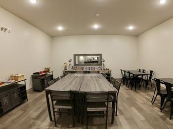Creekside Common room large wooden table with chairs in a room with white walls and hardwood floors